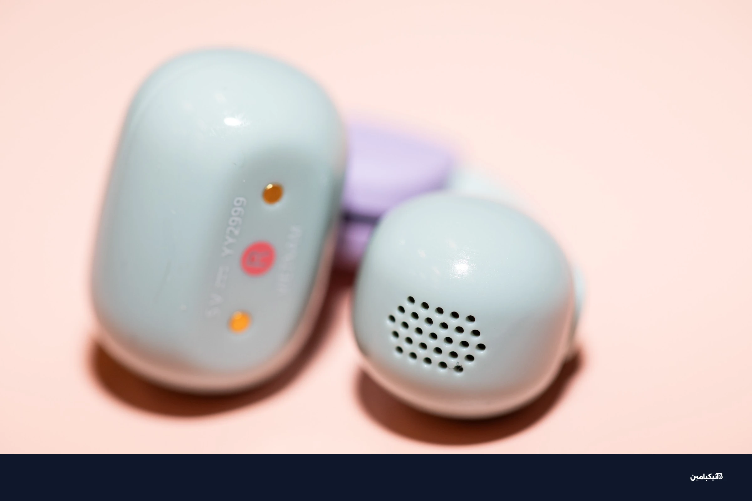 A closeup of the Sony LinkBuds Clip earbuds on a peach colored surface.