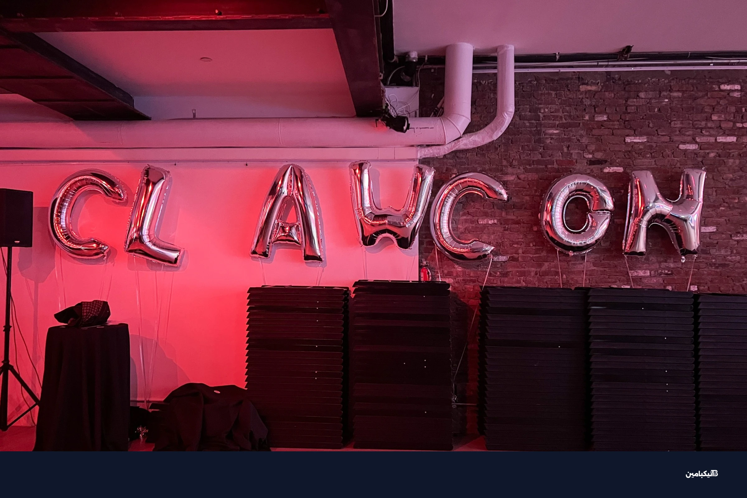 قاعة مؤتمر ClawCon مع إضاءة وردية وبالونات فضية