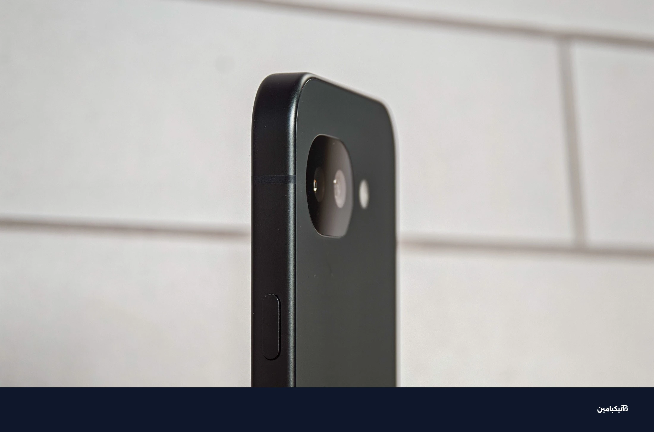 صورة جوجل Pixel 10A أمام بلاط أبيض، تعرض الكاميرا من زاوية