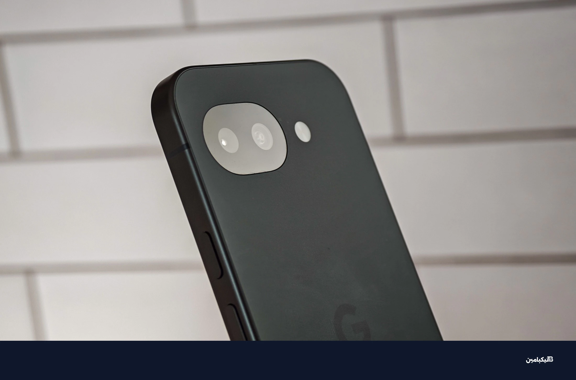 صورة جوجل Pixel 10A أمام بلاط أبيض، تعرض الكاميرا من زاوية