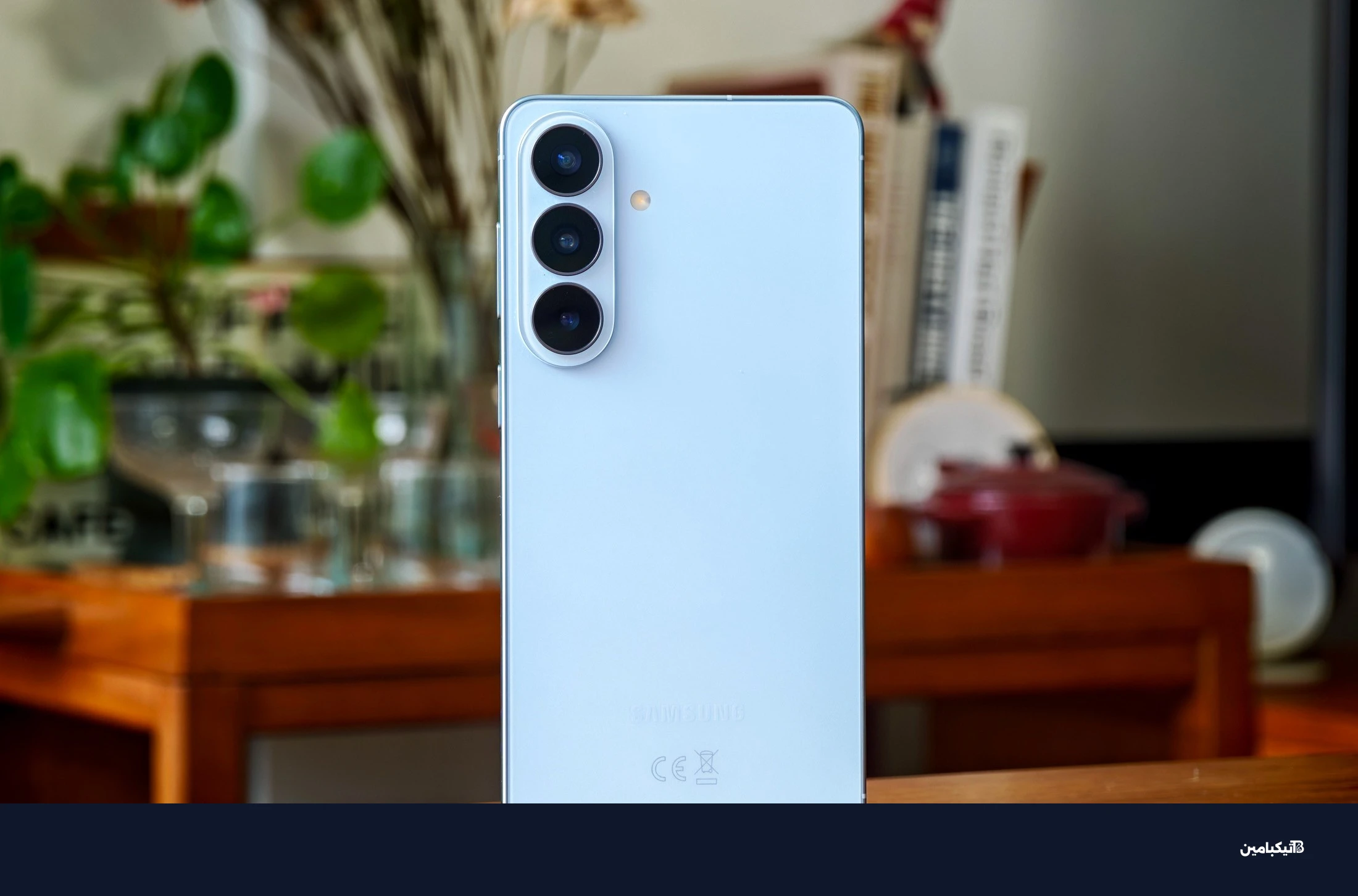 صورة لهاتف سامسونج Galaxy S26 Plus أزرق على طاولة خشبية