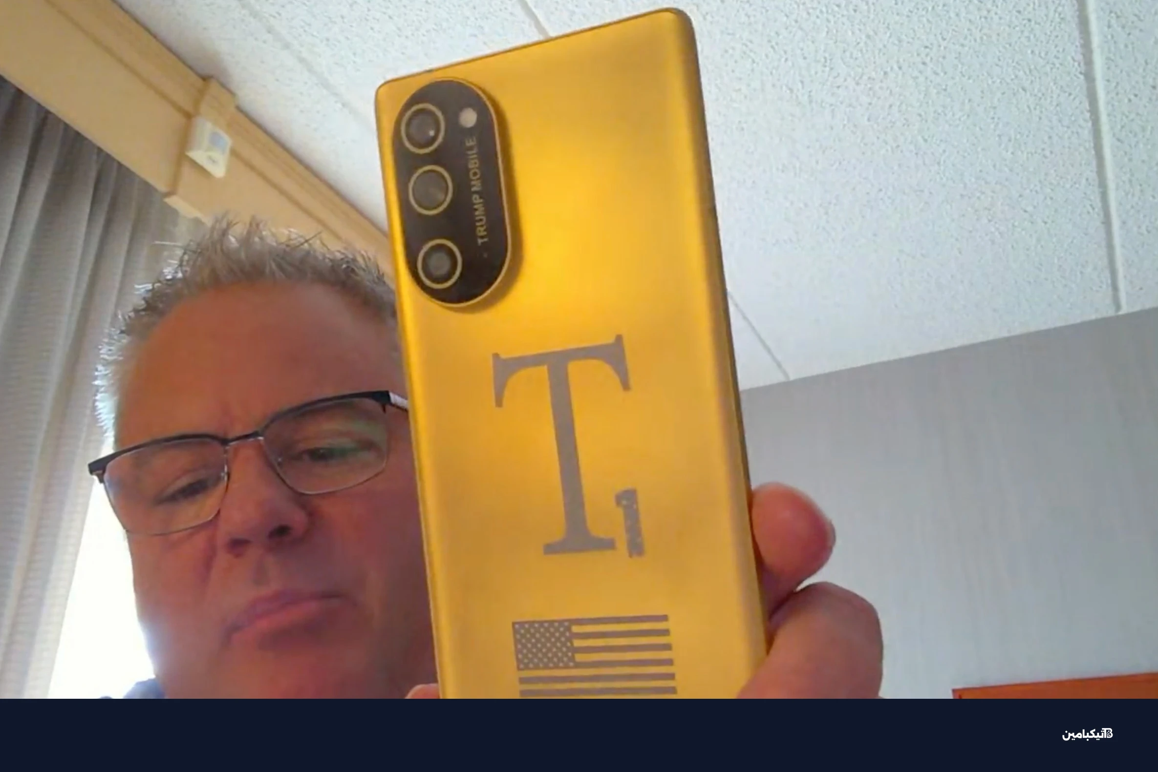 إريك توماس يعرض هاتفاً ذهبياً أمام الكاميرا